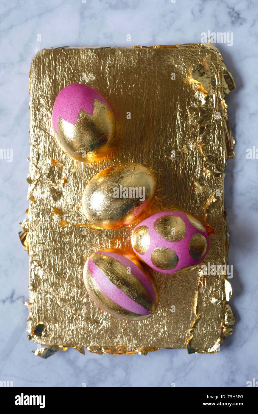 Four painted Easter eggs on golden background and marble Stock Photo