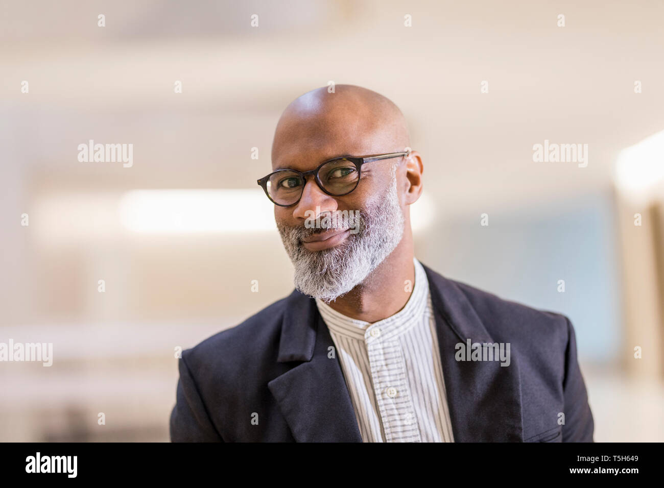 Portrait of bald mature businessman with grey beard wearing glasses ...