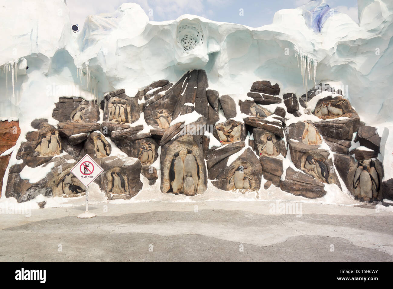 Creative artwork of penguins that has been curved into rocks as a welcome sign to tourists who visit the Antarctica: Empire of the Penguin at Seaworld Stock Photo