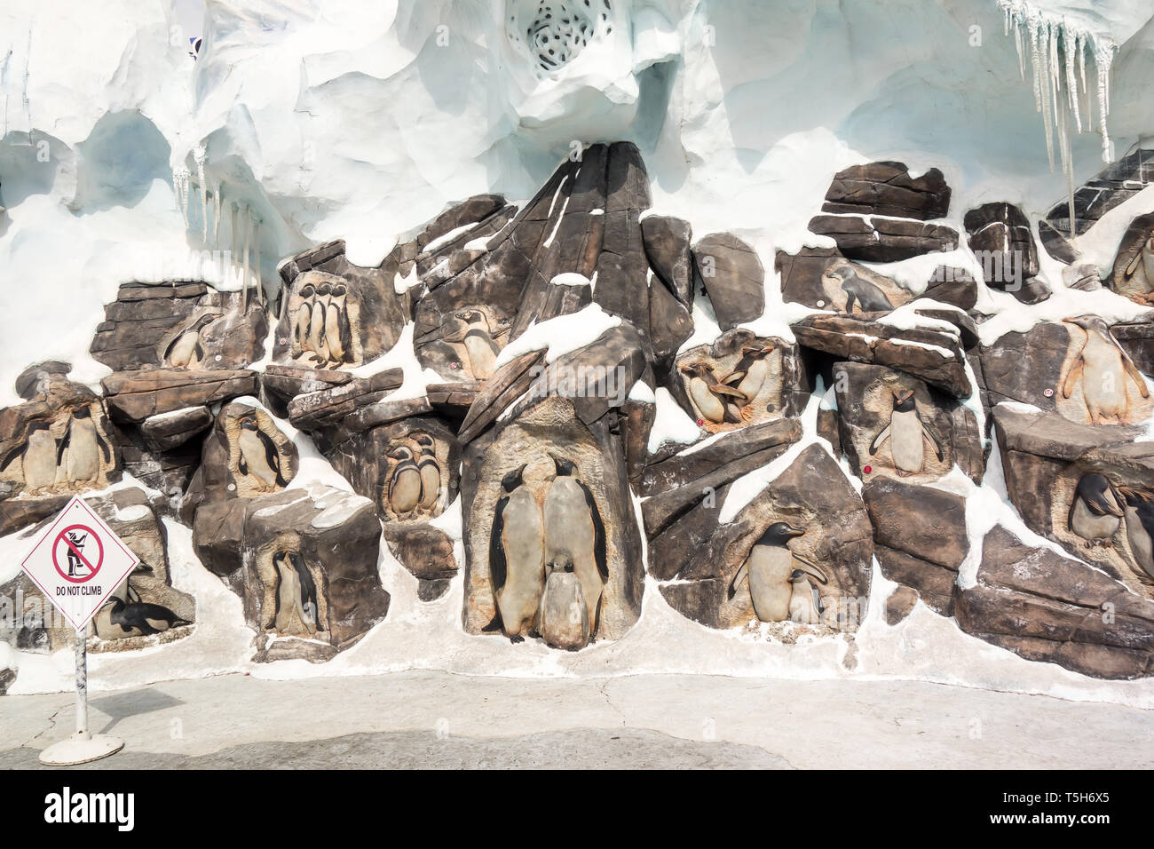 Creative artwork of penguins that has been curved into rocks as a welcome sign to tourists who visit the Antarctica: Empire of the Penguin at Seaworld Stock Photo