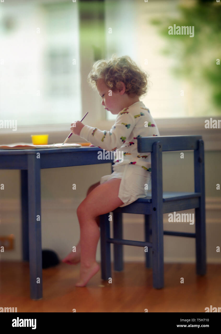 Side view of a kid immersed in painting. Stock Photo