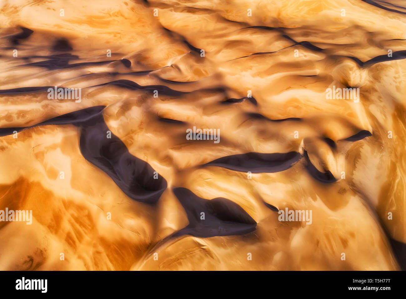 Folds of sand dunes seen from above top down in soft morning sun light highlighting surface of remote intanct lifeless desert land. Stock Photo