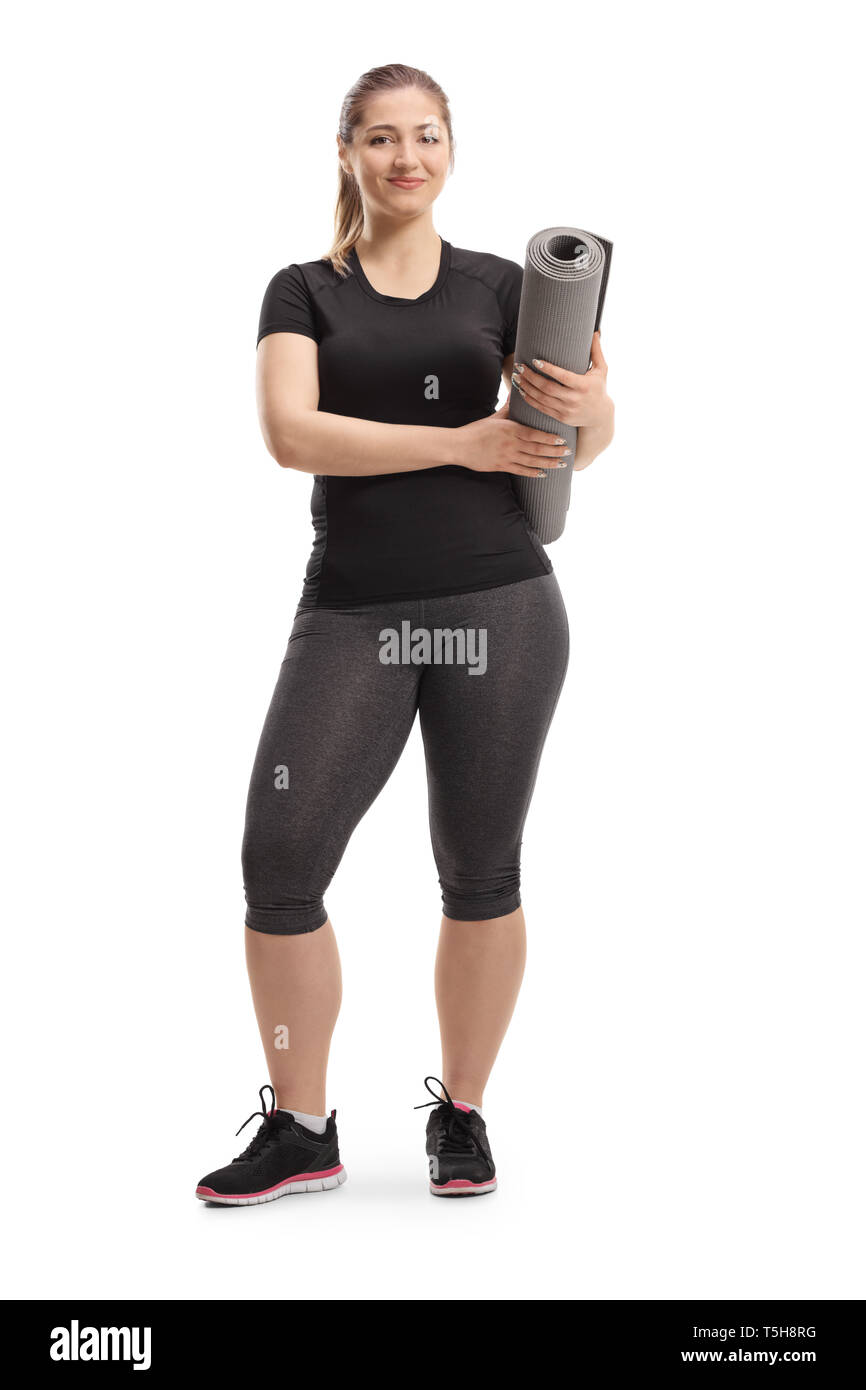 Full length portrait of a young woman posing with an exercising mat ...