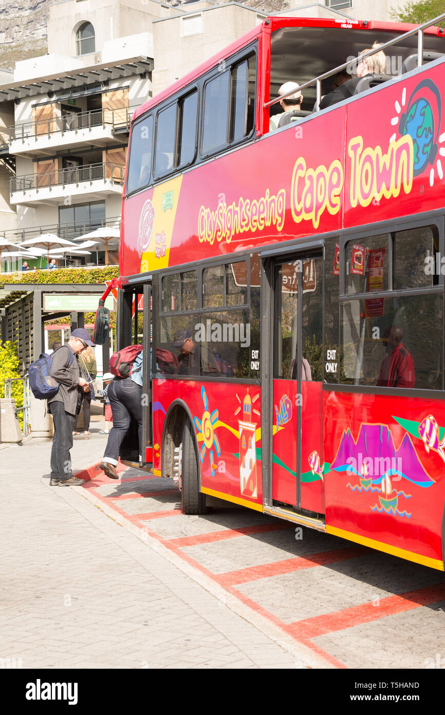 Cape Town city sightseeing red hop on hop off bus parked at Table Mountain lower cableway station at a bus stop with tourists or people boarding Stock Photo