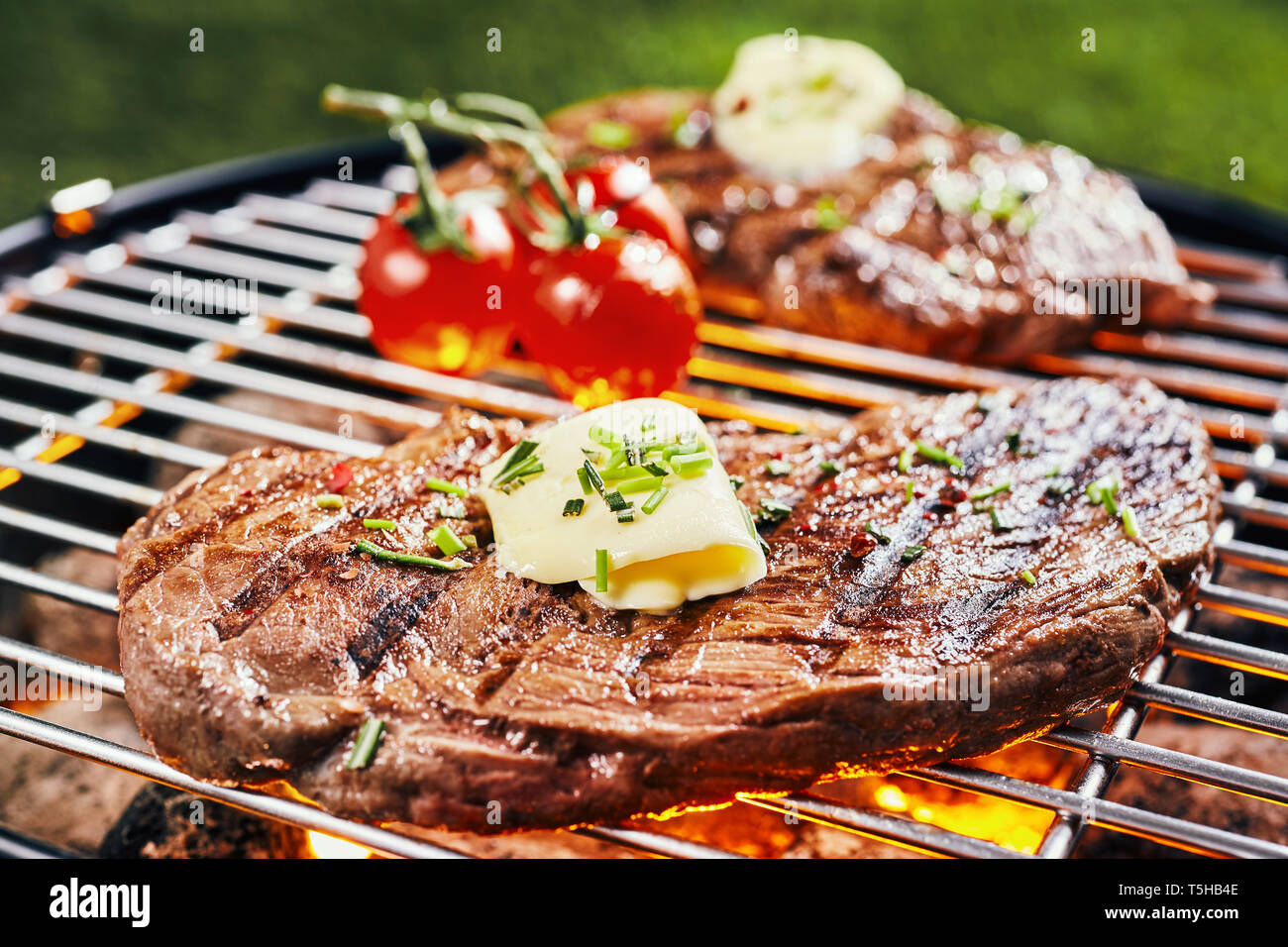 I detaljer hjerne At adskille Succulent portion of rump steak grilling on a hot BBQ fire garnished with a  curl of butter and fresh herbs Stock Photo - Alamy