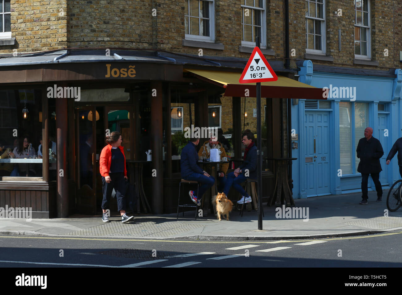 people seated and walking in front of a Spanish restaurant in