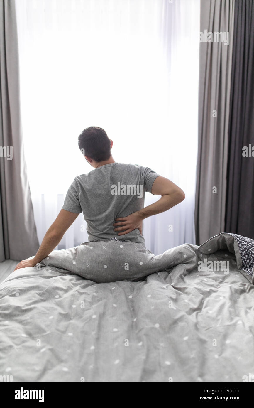 Man Suffering From Back Pain At Home In The Bedroom Stock Photo Alamy