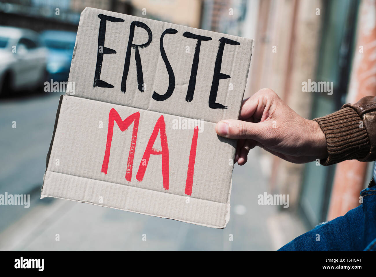closeup of a young caucasian man outdoors showing a brown cardboard