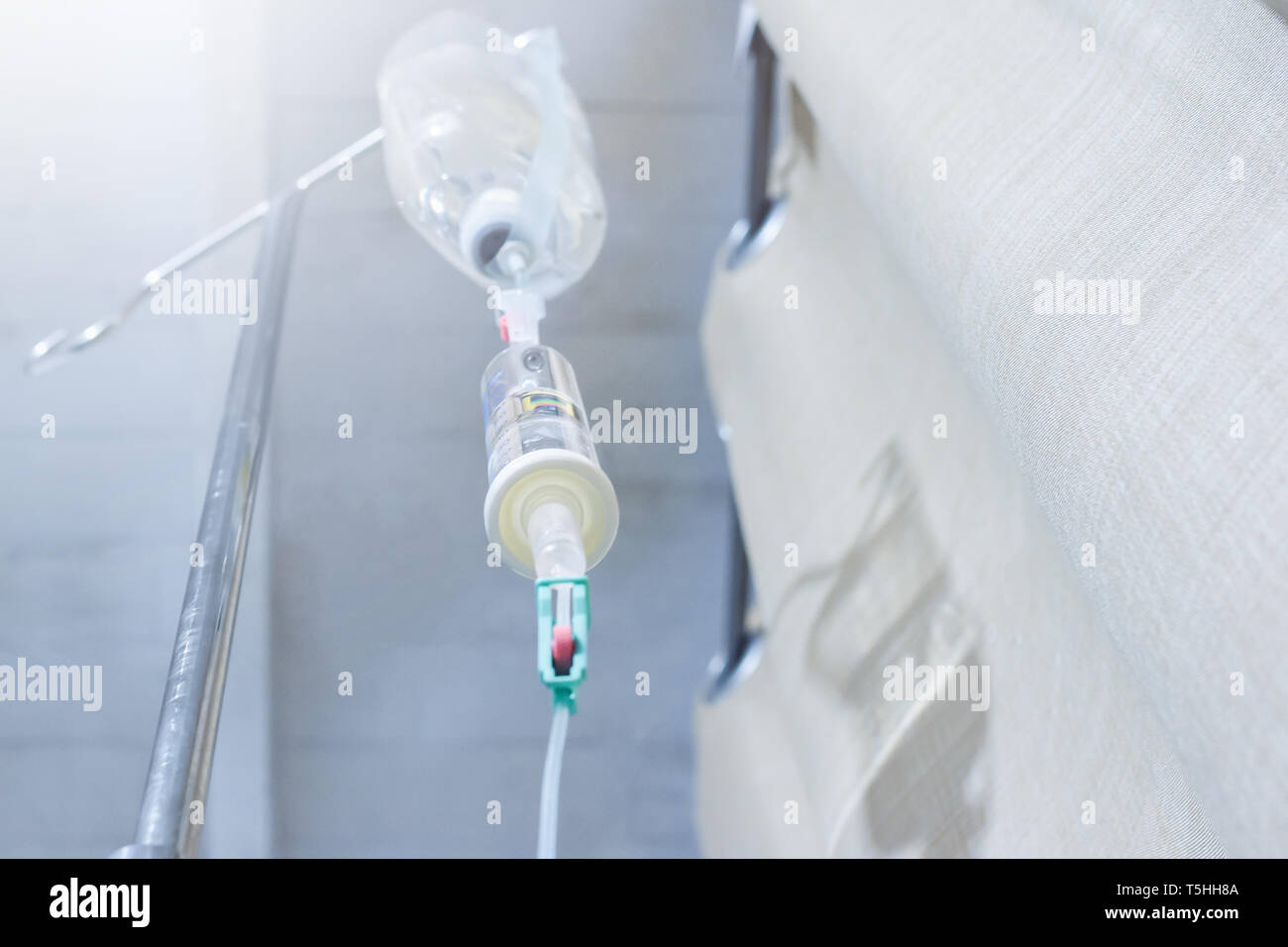 iv solution infusion, bottom view of saline bottle from the eyes of the patient on bed in the patient room Stock Photo