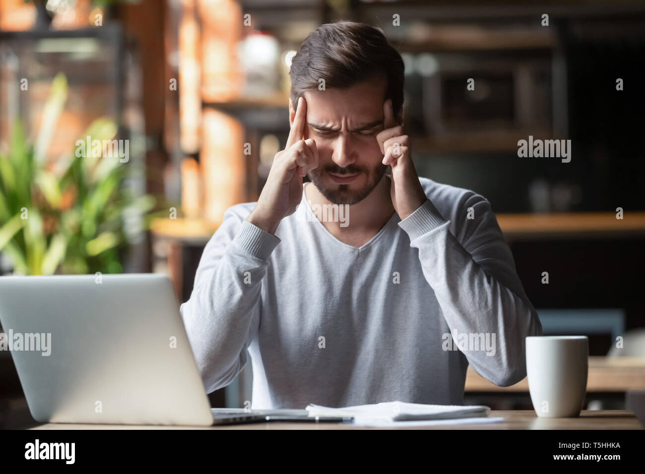 Man touching with fingers forehead thinking or suffering from headache Stock Photo