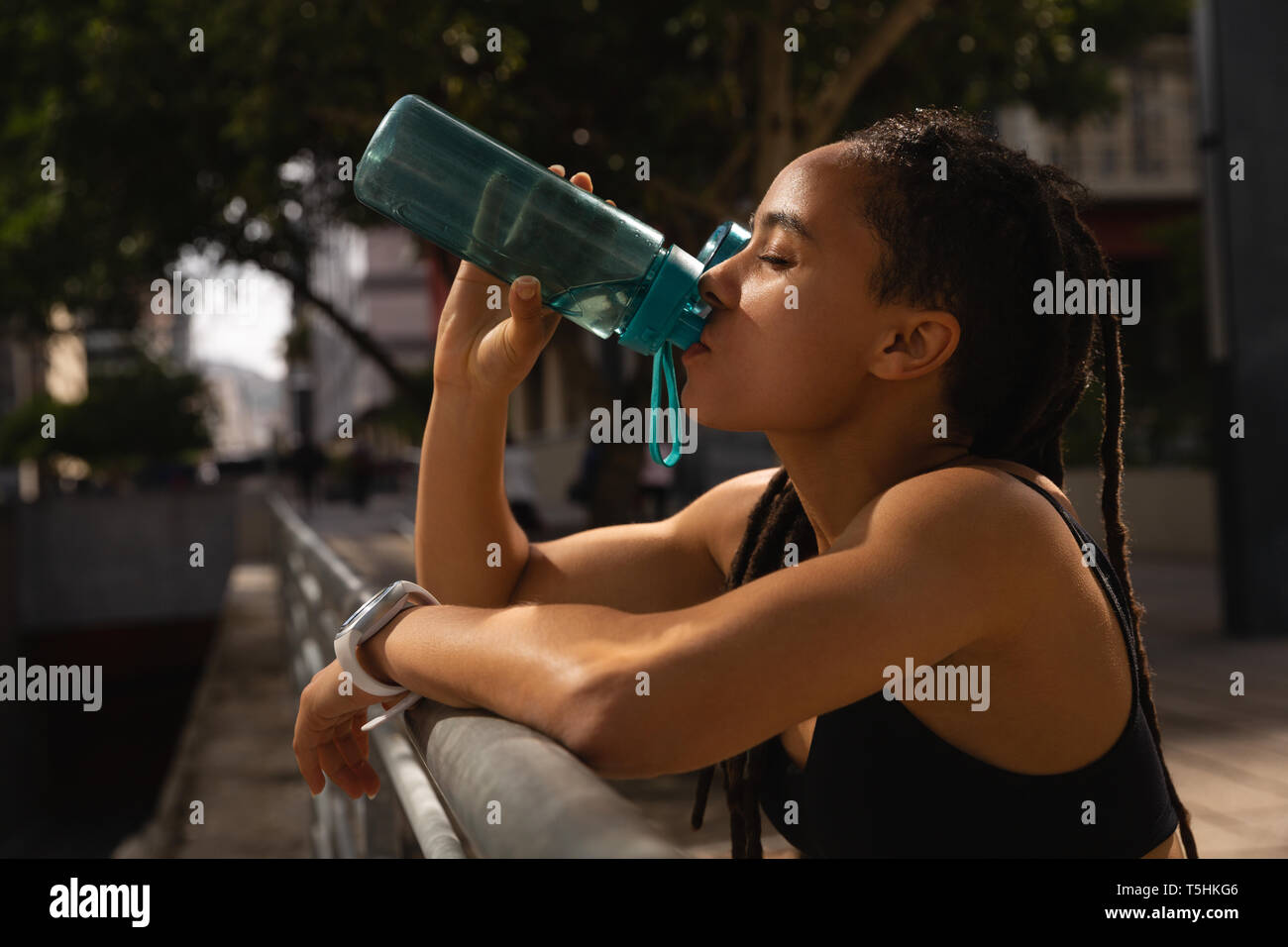 Young woman drinking water in the city Stock Photo