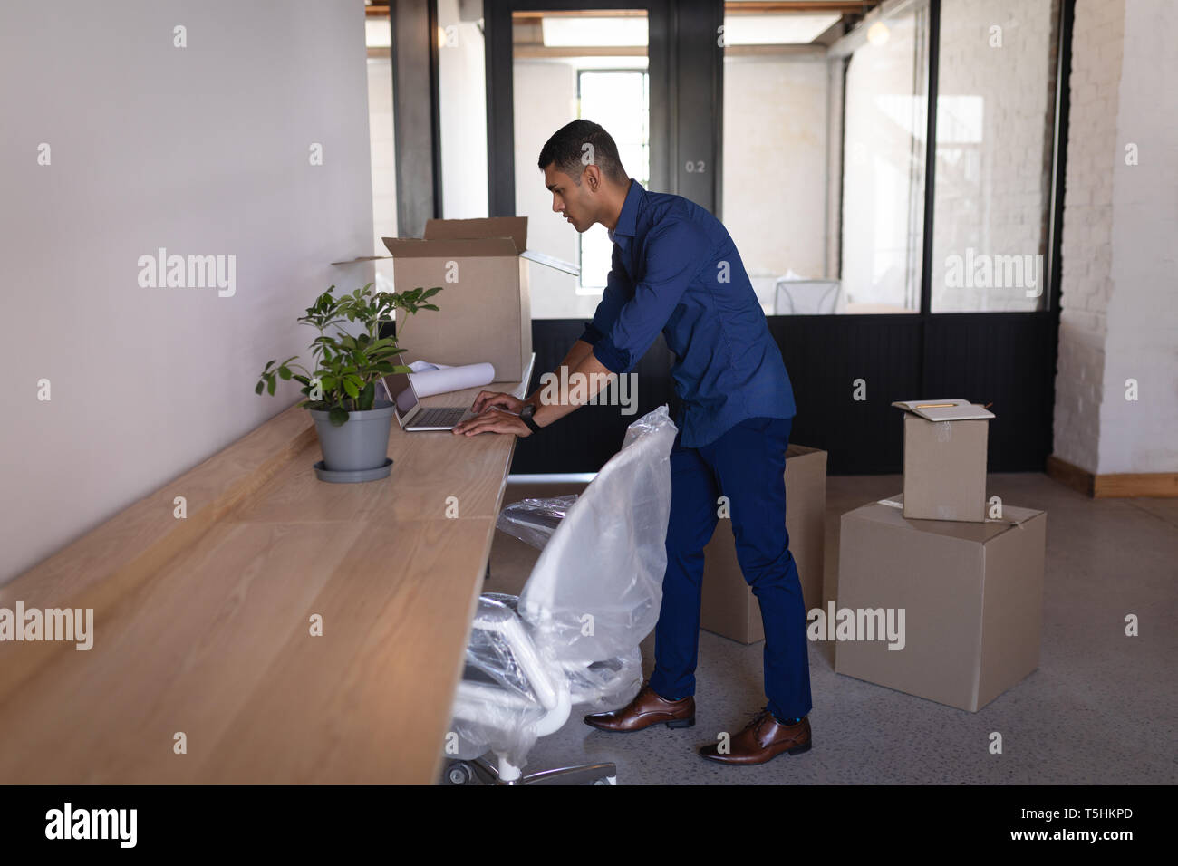 Businessman using laptop at desk in new office Stock Photo