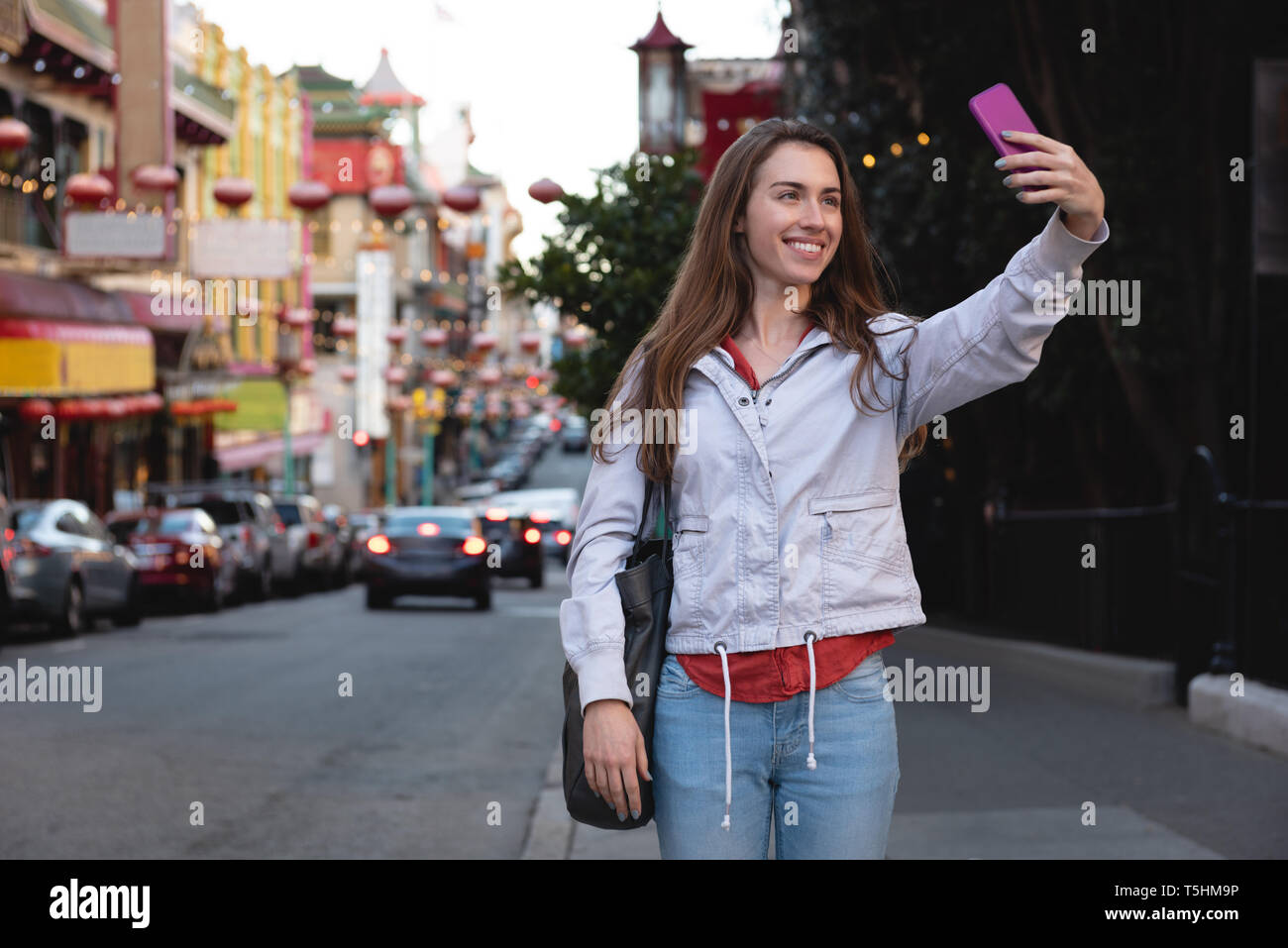 Beautiful woman taking selfie while standing on side walk Stock Photo ...