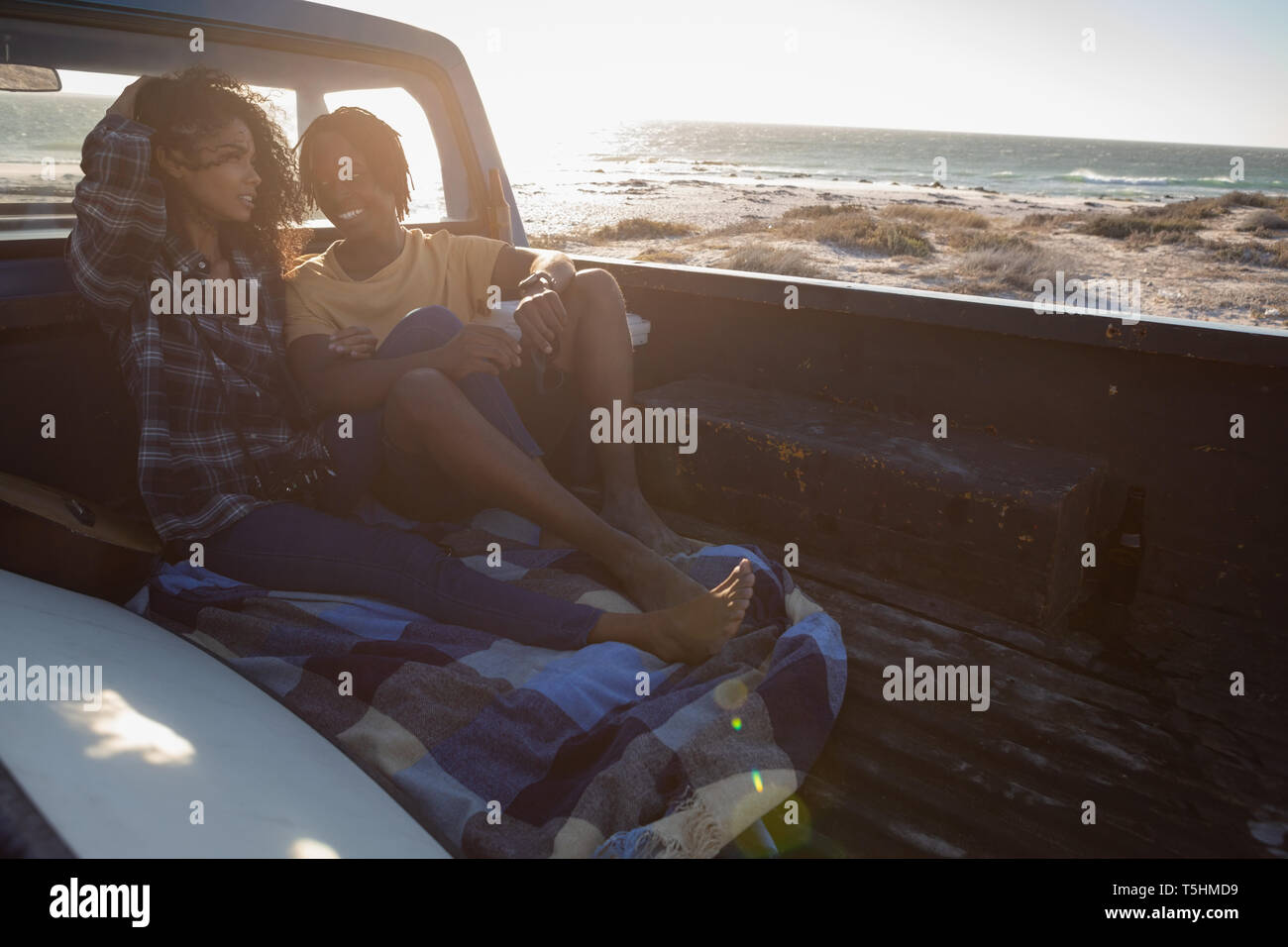 Couple interacting with each other while sitting in car at beach Stock Photo