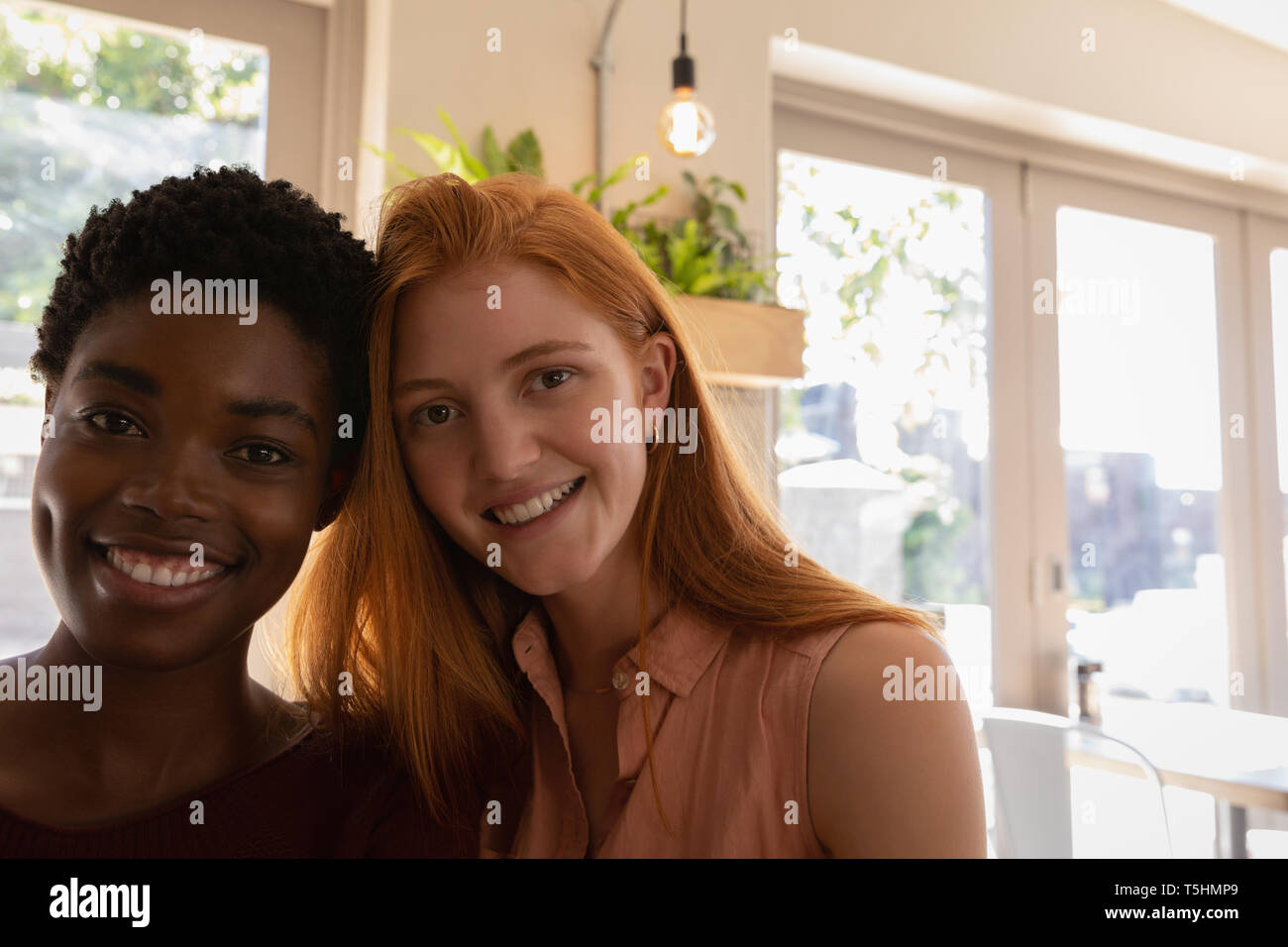 Young female friends smiling in a cafe Stock Photo