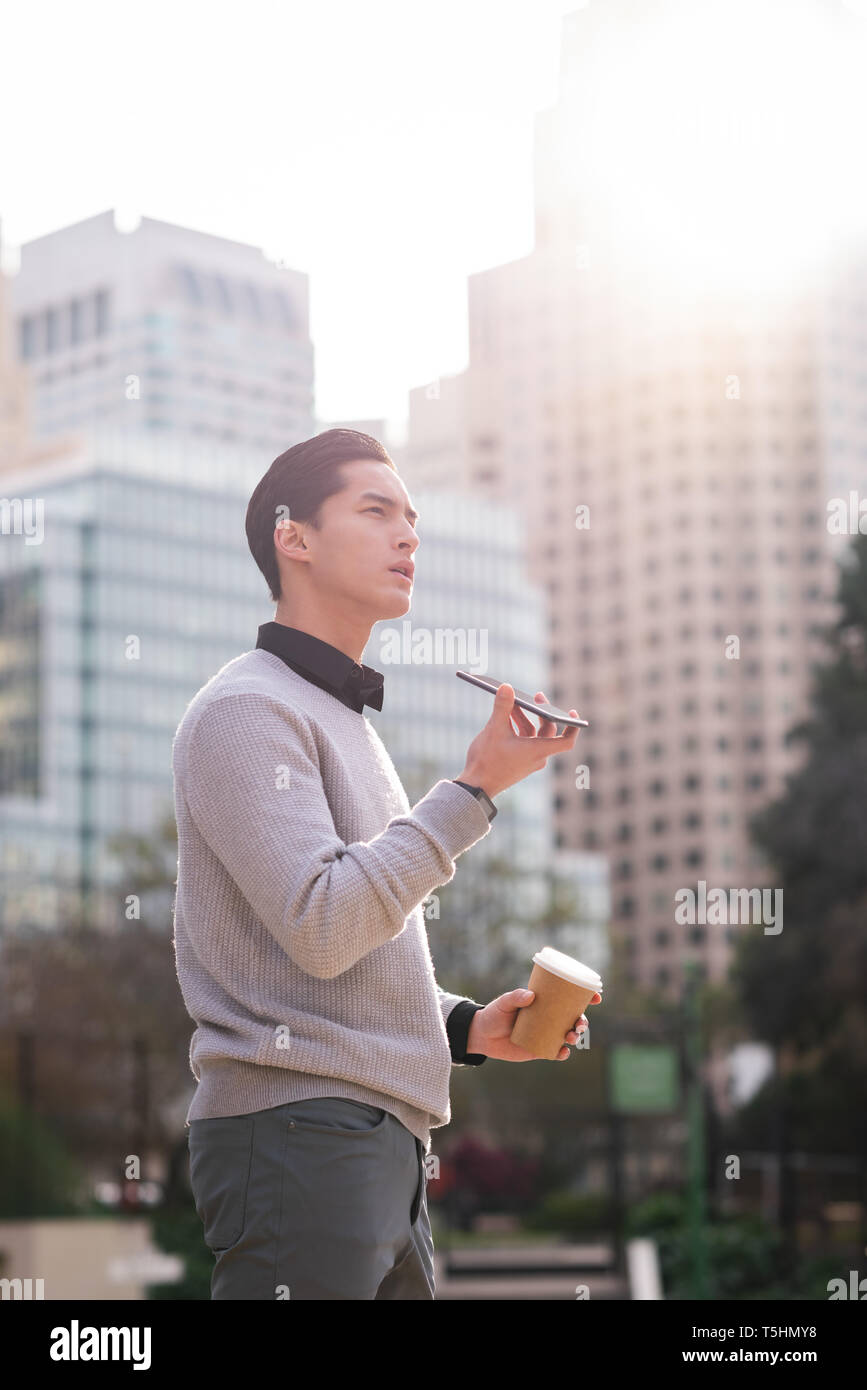Man talking on mobile phone while standing on street Stock Photo