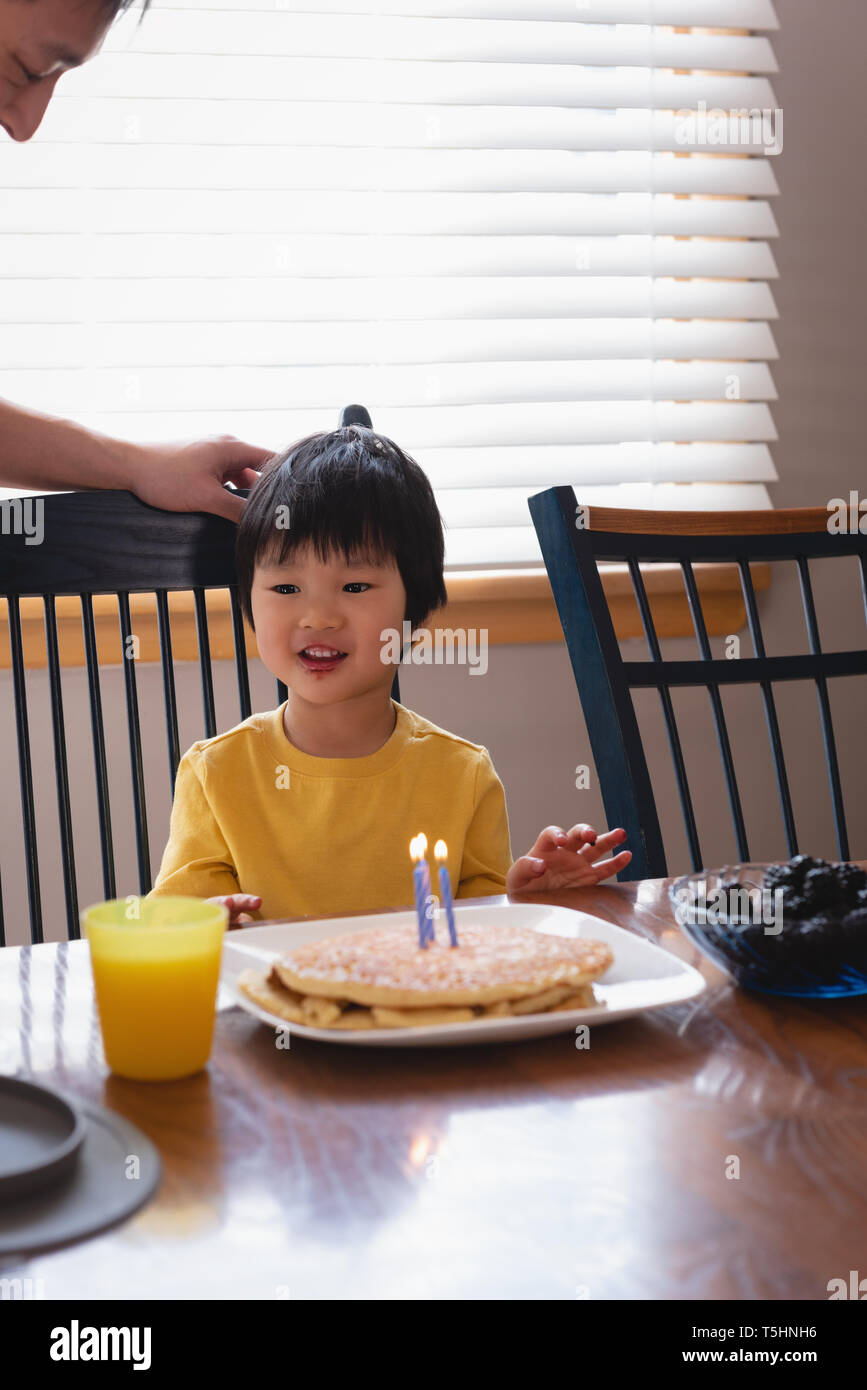 Father and son enjoying on dining table in kitchen Stock Photo