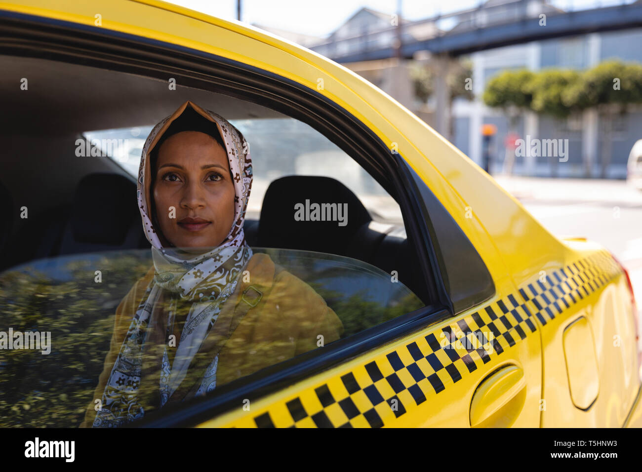 Thoughtful woman sitting in taxi Stock Photo