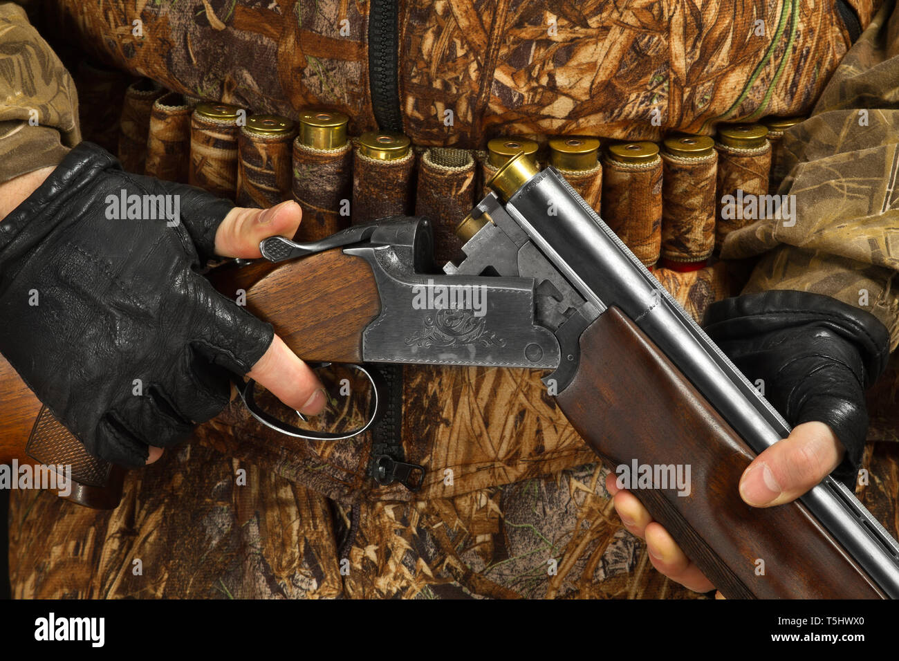 hands of hunter in camouflage holding the double-barreled shotgun, closeup Stock Photo