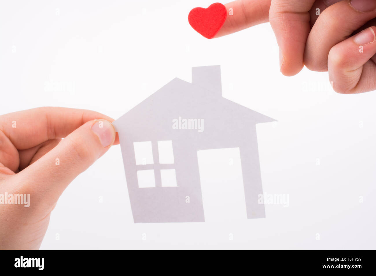 Paper house and heart shape in hand on a white background Stock Photo ...