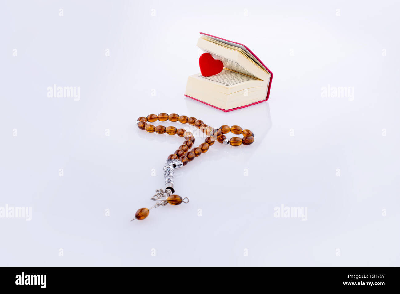 The Holy Quran with a heart and tesbih on a white background Stock ...