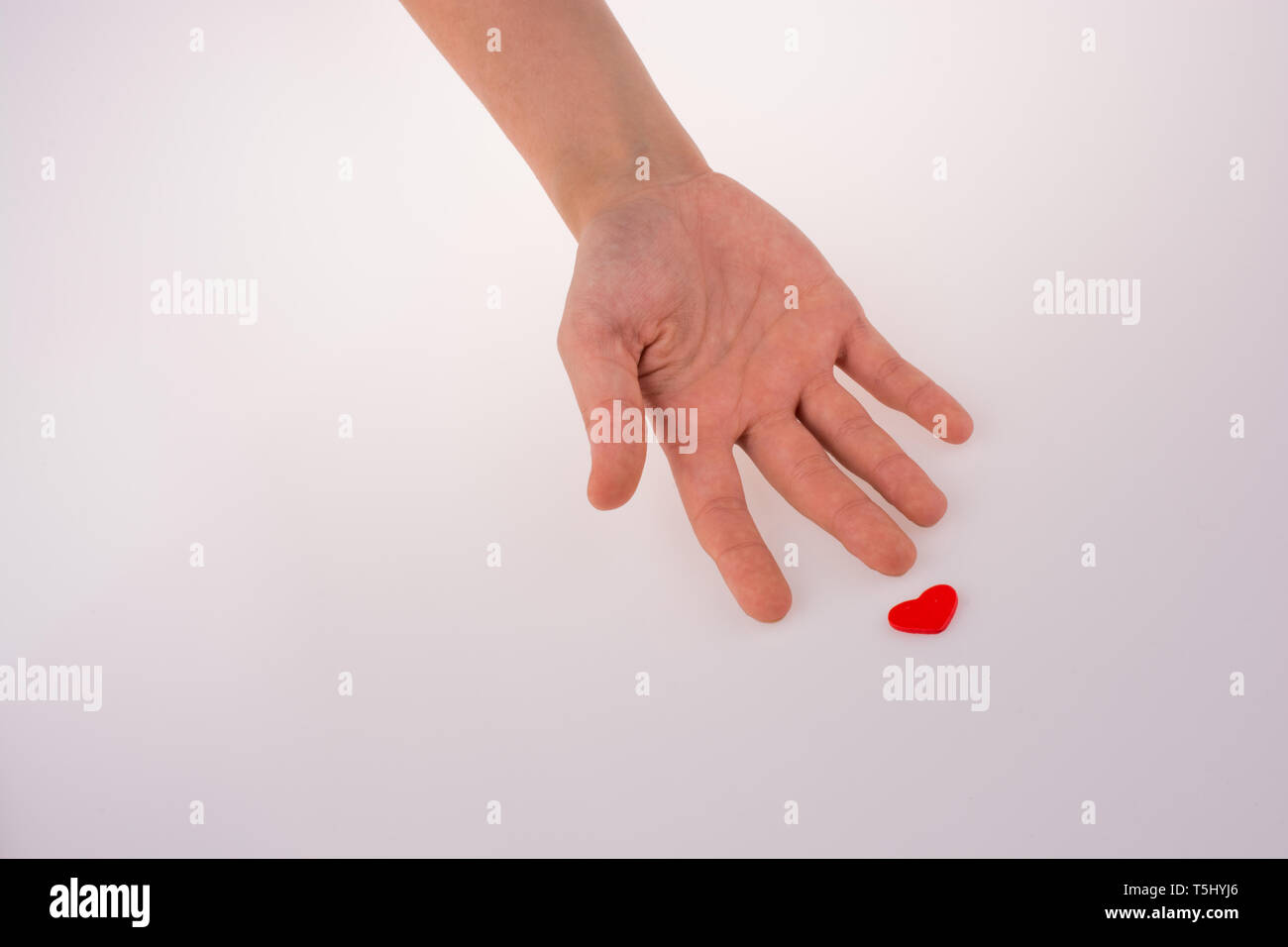 Hand with a red heart on a white background Stock Photo - Alamy