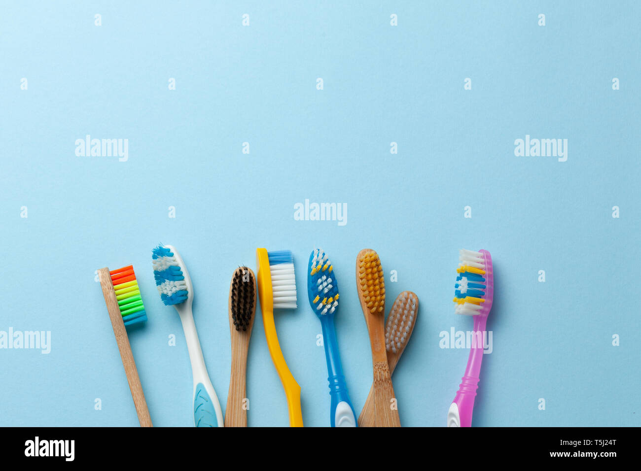 Colored toothbrushes on blue background. Copy space for text Stock Photo
