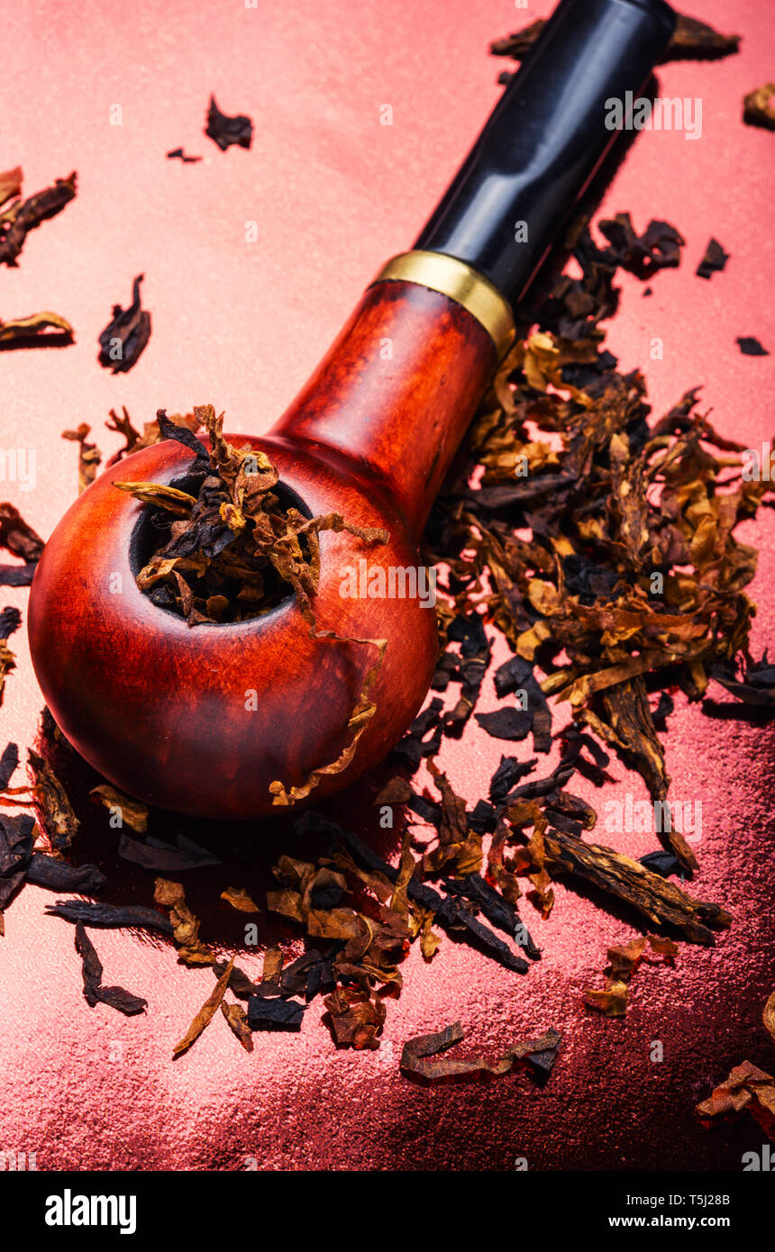Tobacco pipe with tobacco and scattered virgin tobacco Stock Photo