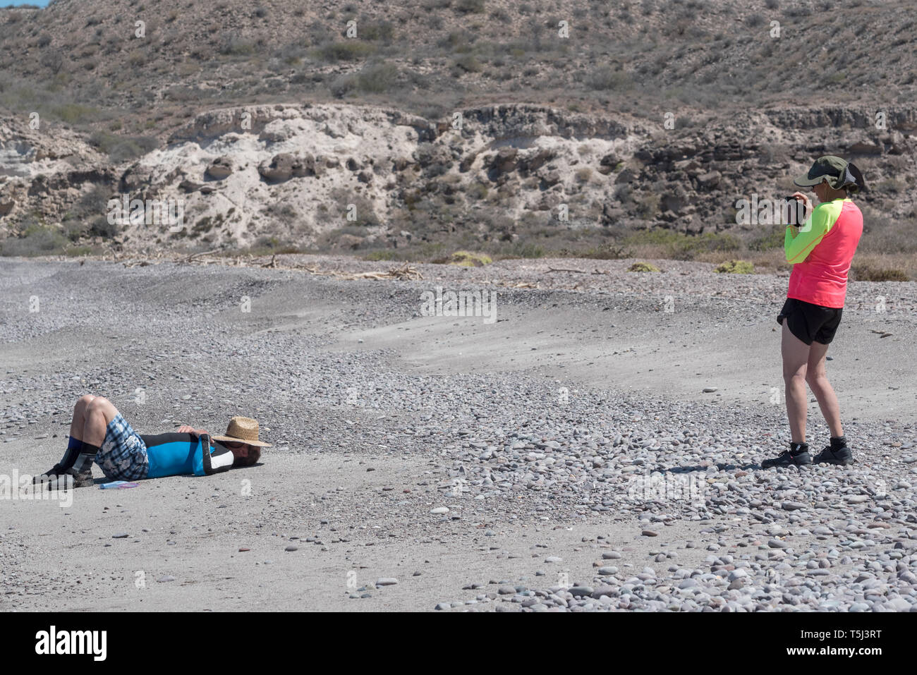 WIfe taking picture of napping husband, Bay of Loreto Nat. Park, Baja California Sur, Mexico. Stock Photo