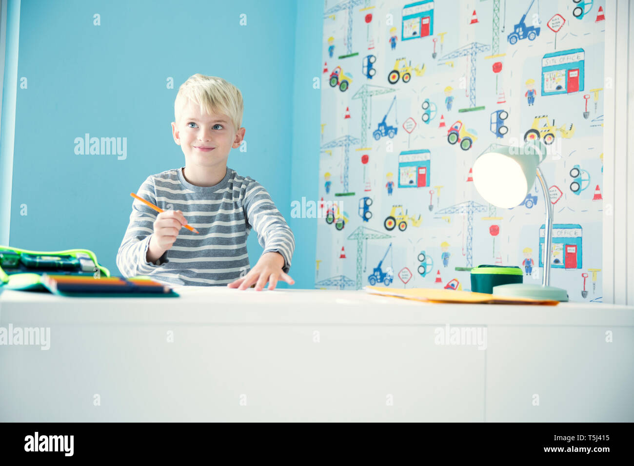Smiling Boy Doing Homework At Desk In Children S Room Stock Photo