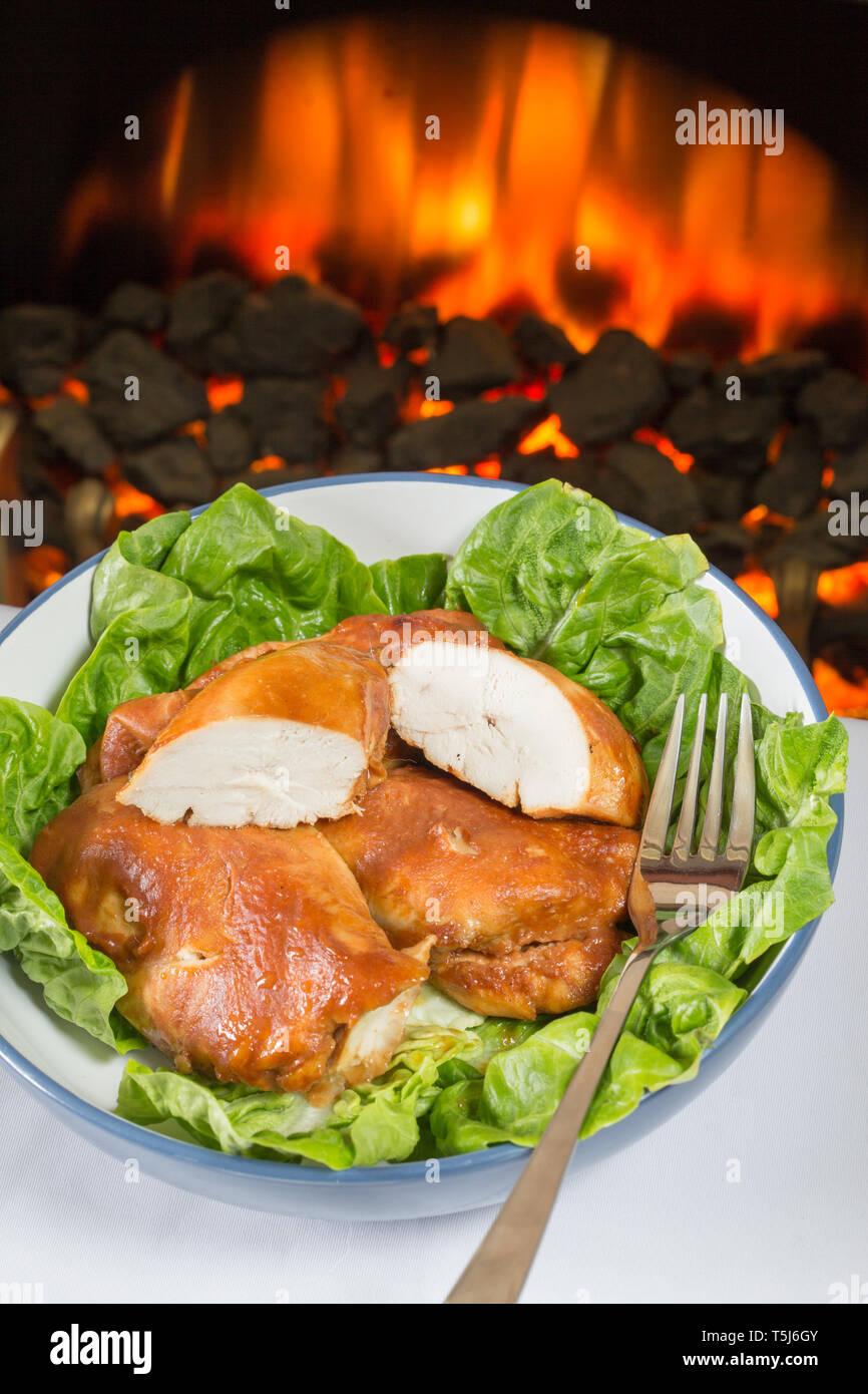 A serving dish of BBQ Chicken breasts with Little Gem lettuce. Stock Photo