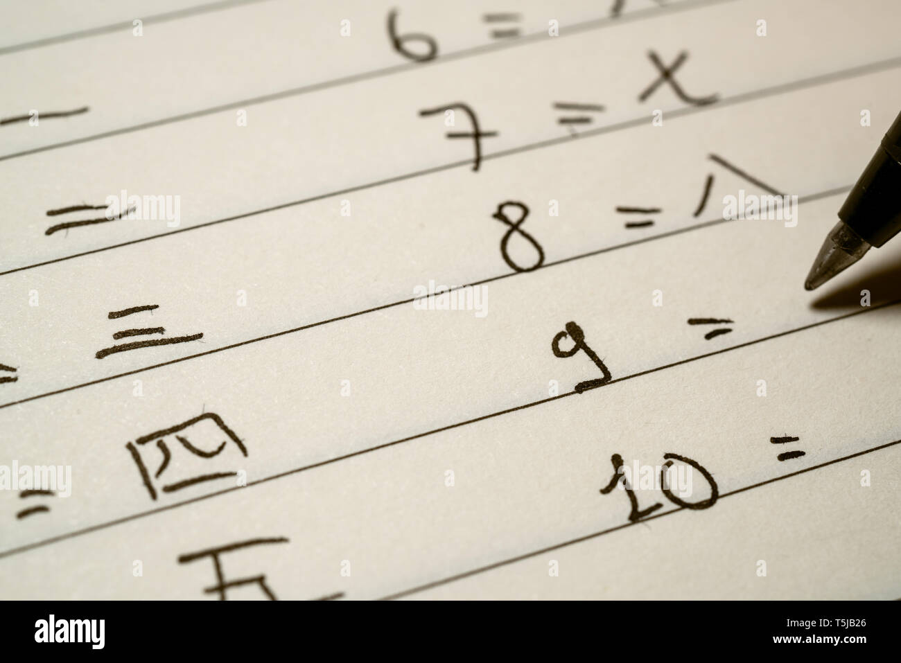 Beginner Chinese language learner writing numbers in Chinese characters macro shot Stock Photo