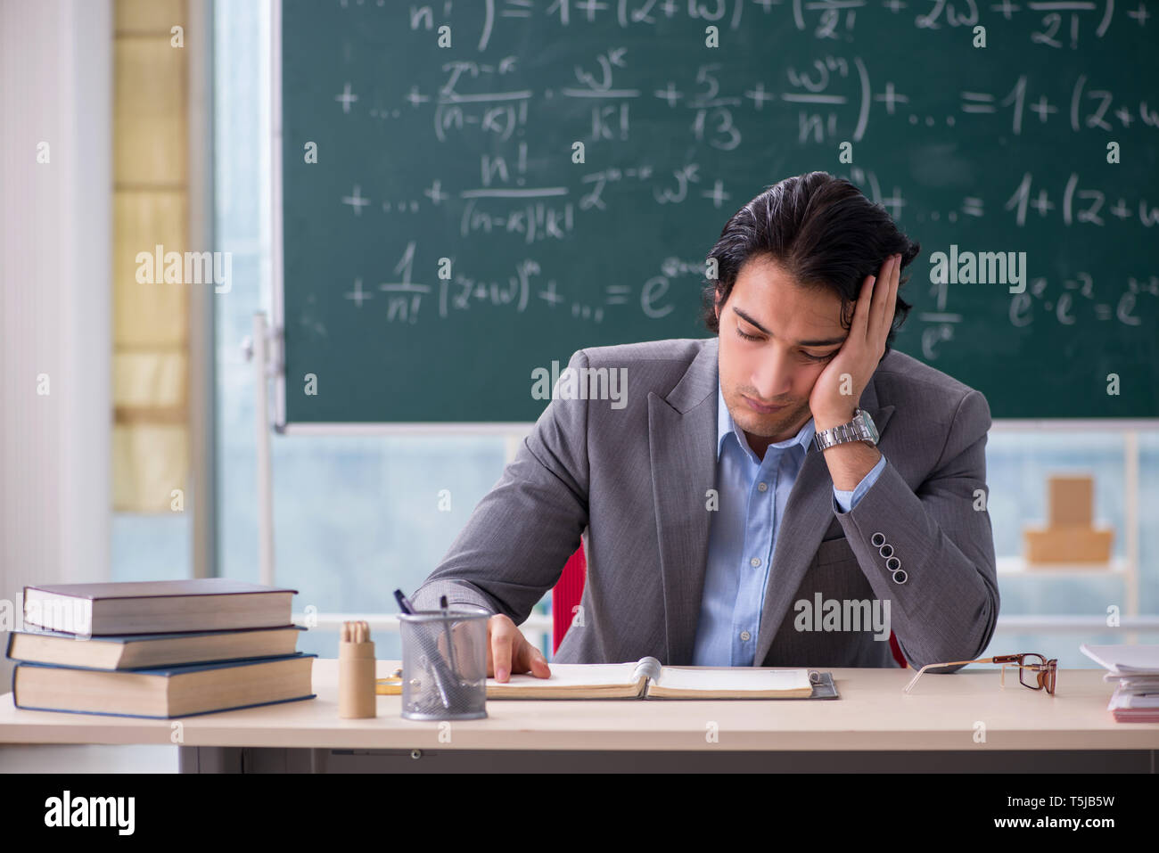 Young handsome math teacher in classroom Stock Photo