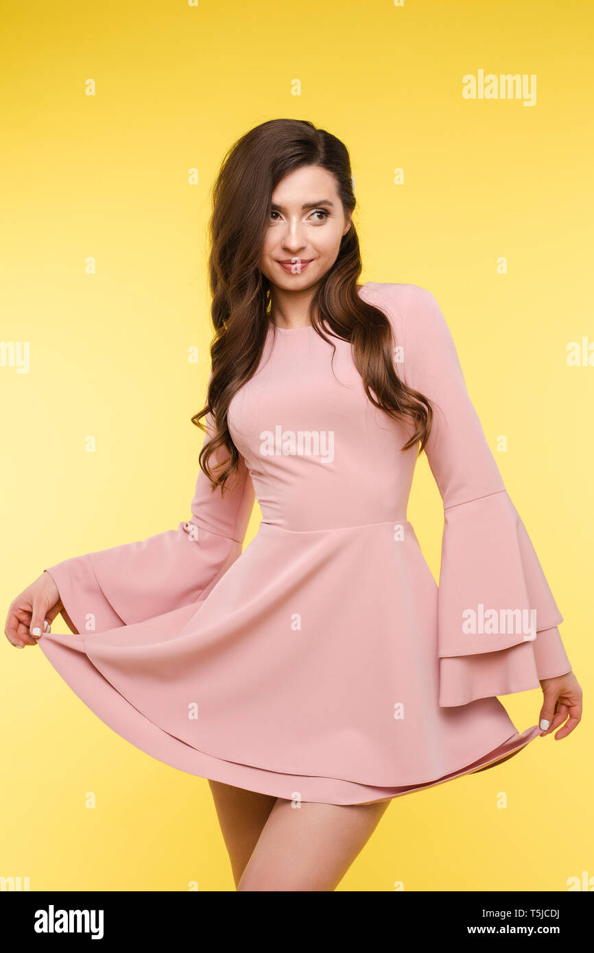Beautiful girl in short pink dress and trendy hairstyle Stock Photo - Alamy