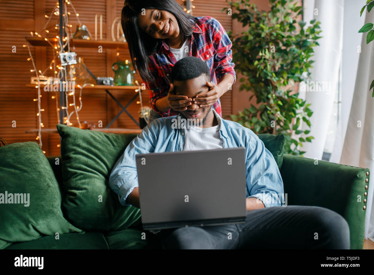 Black couple with laptop having fun on sofa at home. Happy african love ...