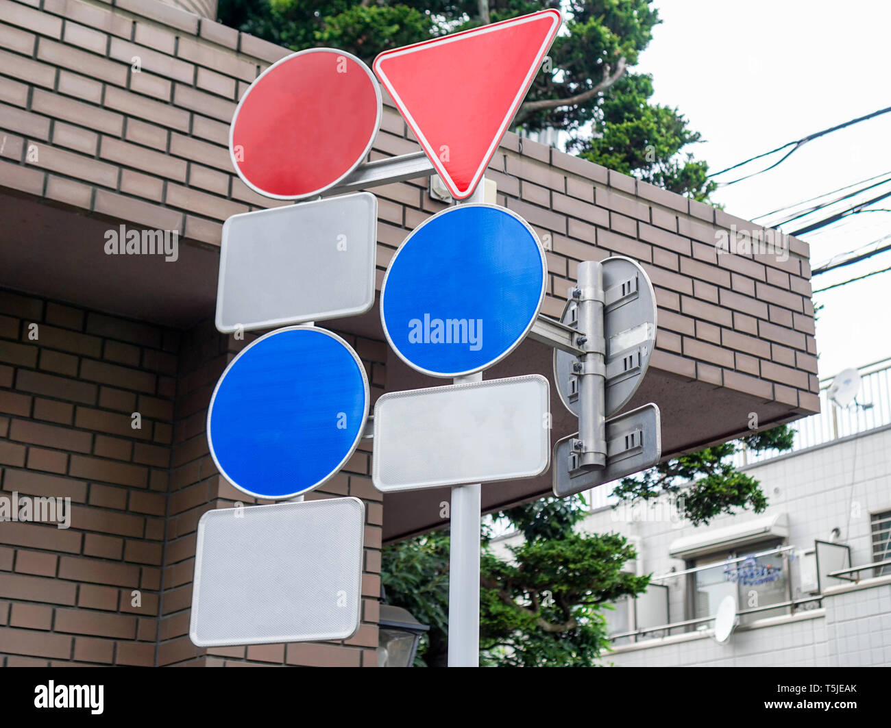 Many road signs safety blue red blank pole on crossroad Stock Photo