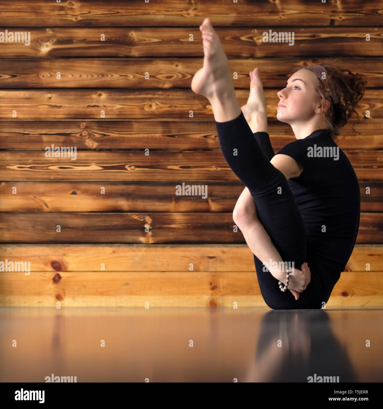 woman practicing yoga, doing Navasana exercise variation, boat pose ...