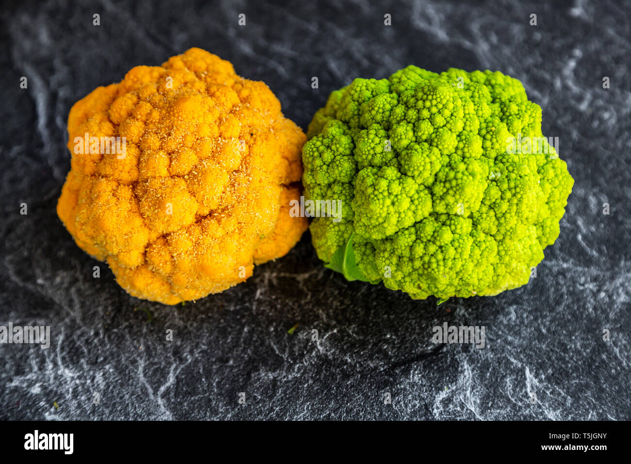 Yellow and bright green cauliflower on slate Stock Photo