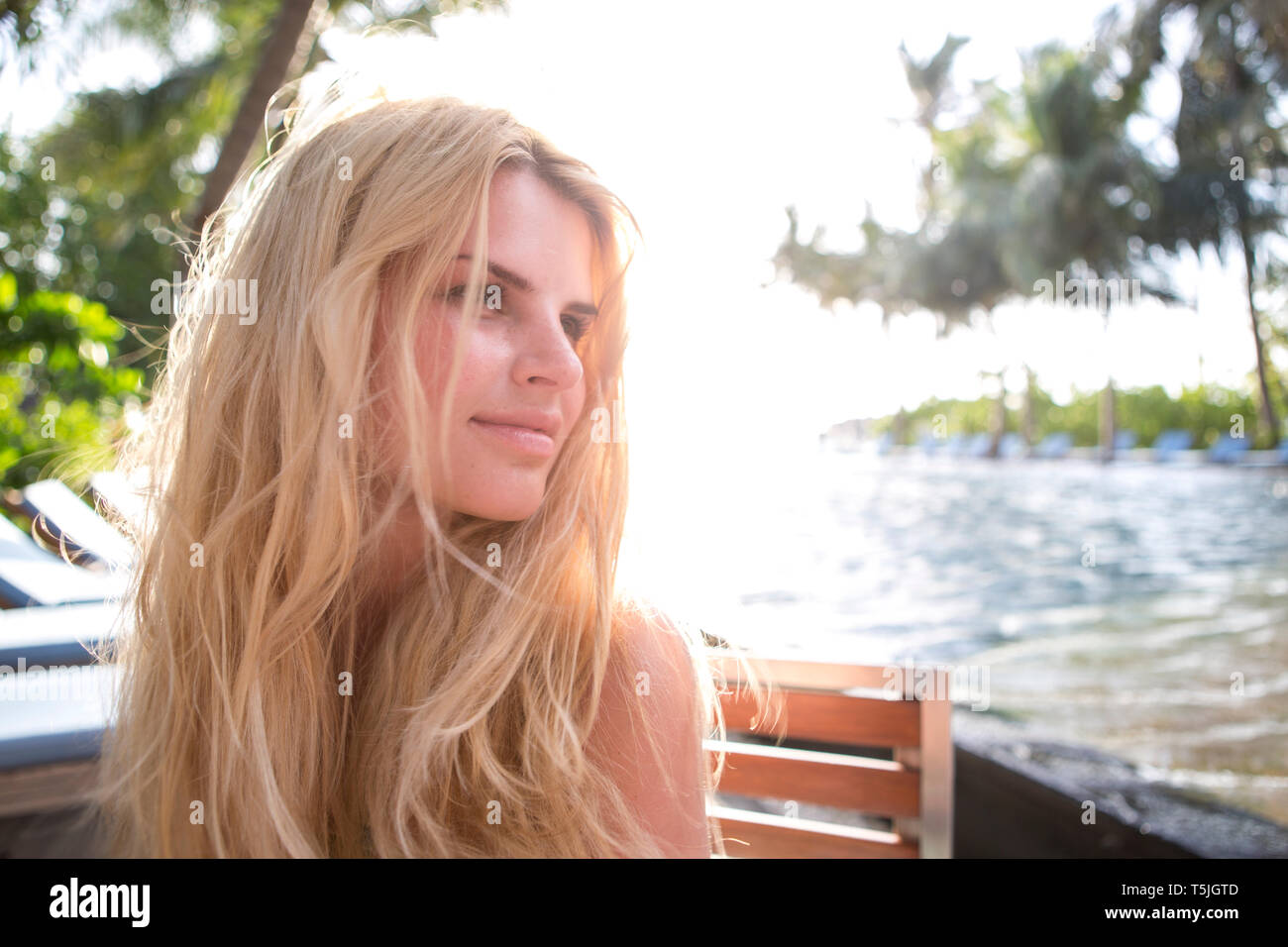 Beautiful blond woman sitting at sea, porttrait Stock Photo