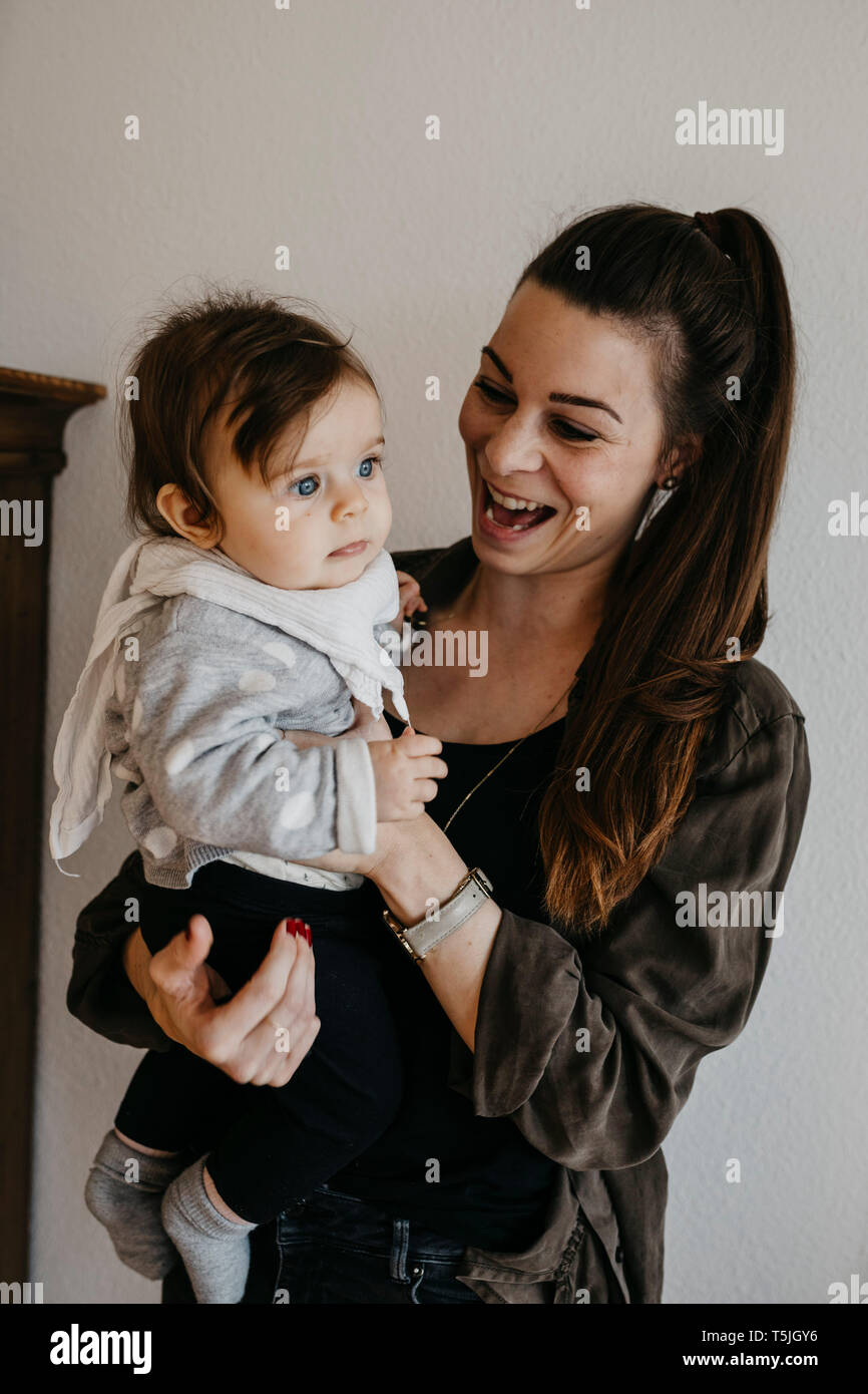 Happy mother carrying baby girl at home Stock Photo Alamy