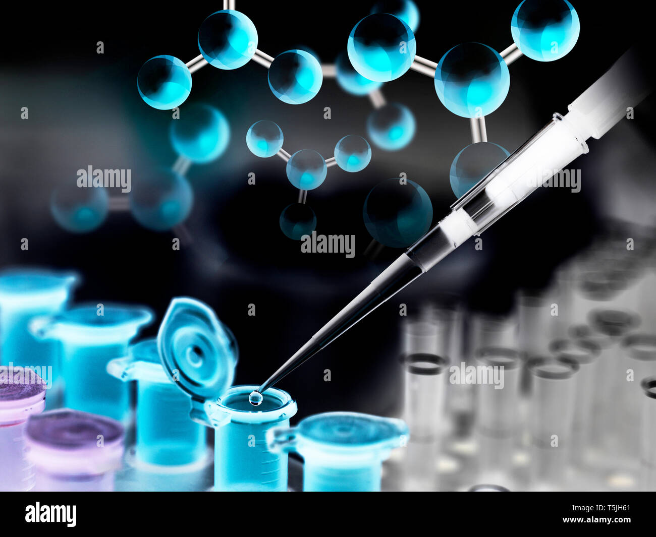 A chemical sample being pipetted into a eppendorf tube with a chemical compound in the background Stock Photo