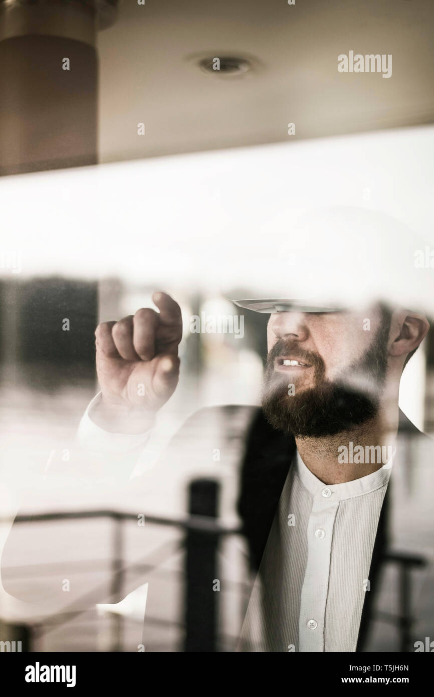 Businessman standing at the window, using VR glasses Stock Photo