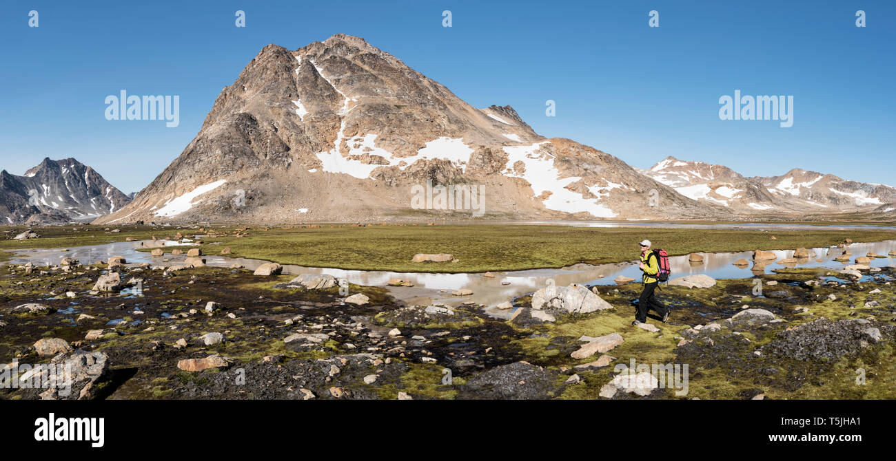 Greenland, Sermersooq, Kulusuk, Schweizerland Alps, woman walking at a brook Stock Photo
