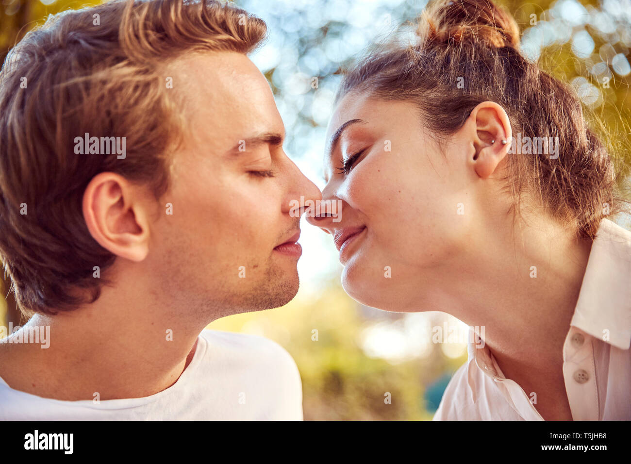 Young couple in love kissing at a park Stock Photo - Alamy
