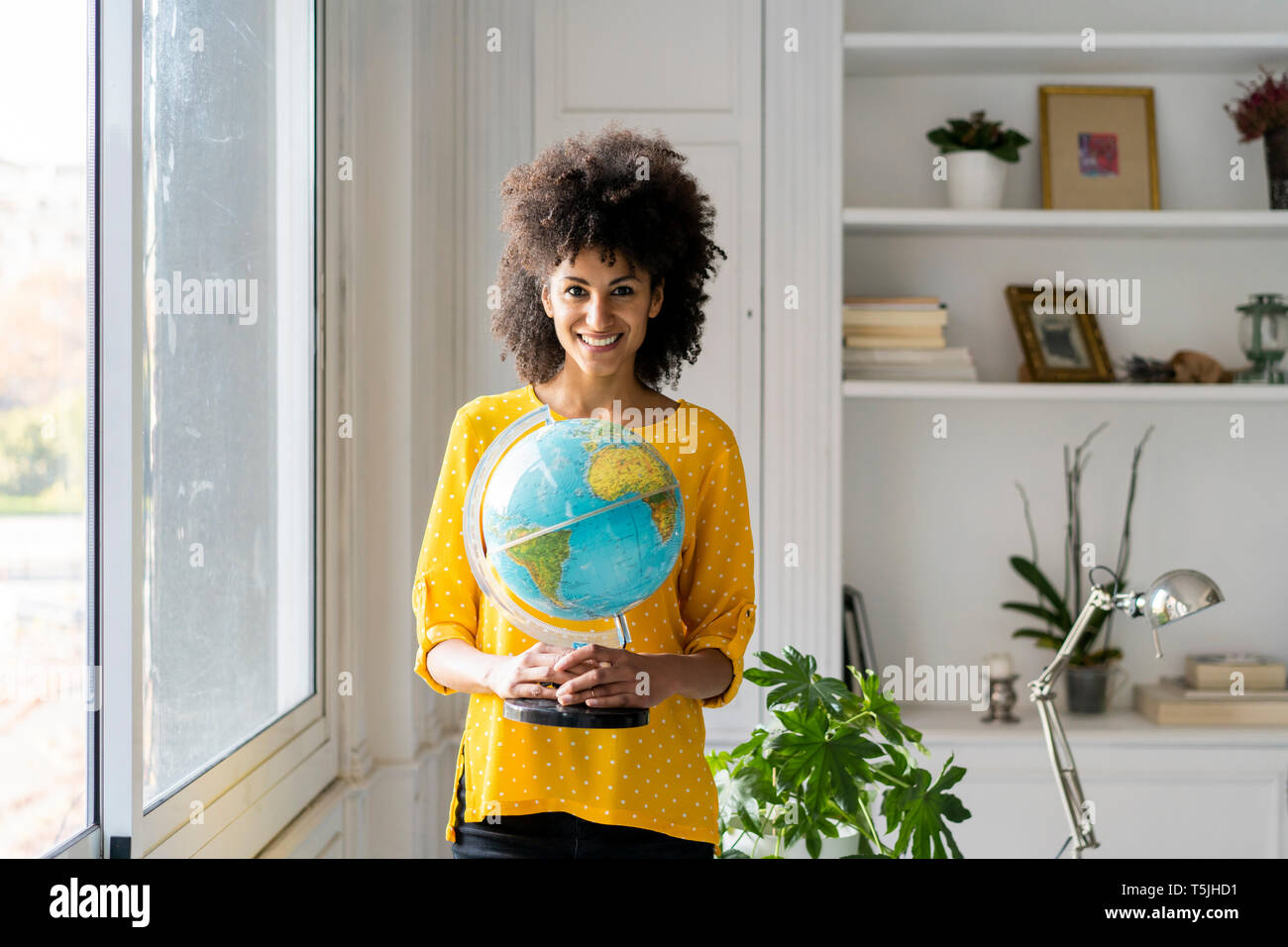 Beautiful woman holding globe, planning vacations Stock Photo