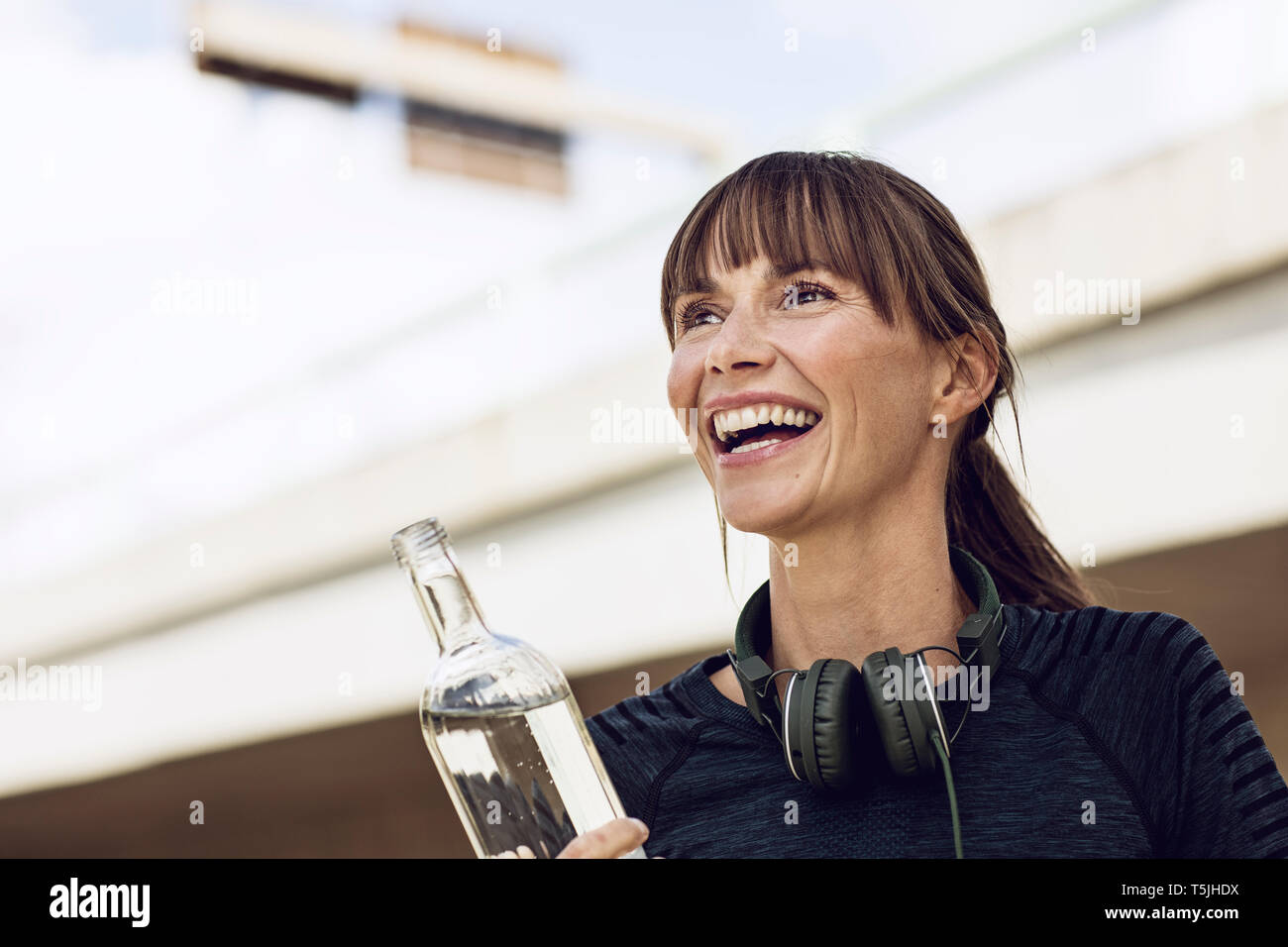 Sportive woman with headphones, doing her fitness training outdoors Stock Photo
