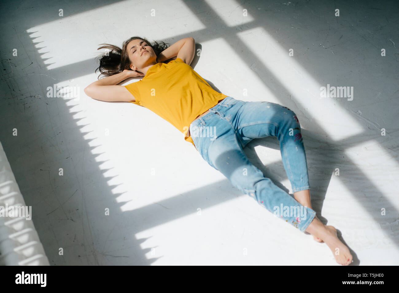 Woman lying on floor, relaxing in the sunlight Stock Photo Alamy