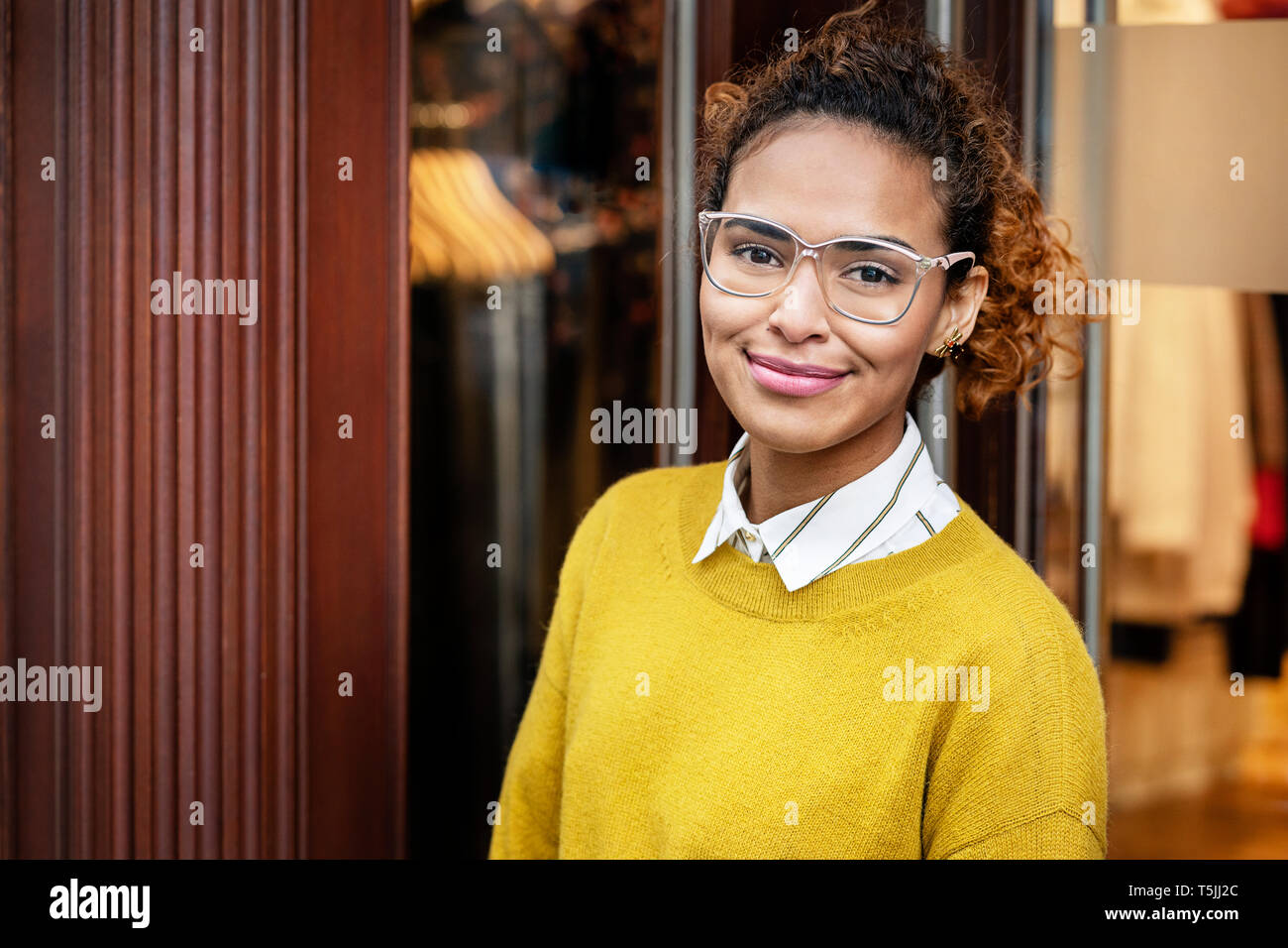 Young woman standing in door of a fashion store Stock Photo - Alamy