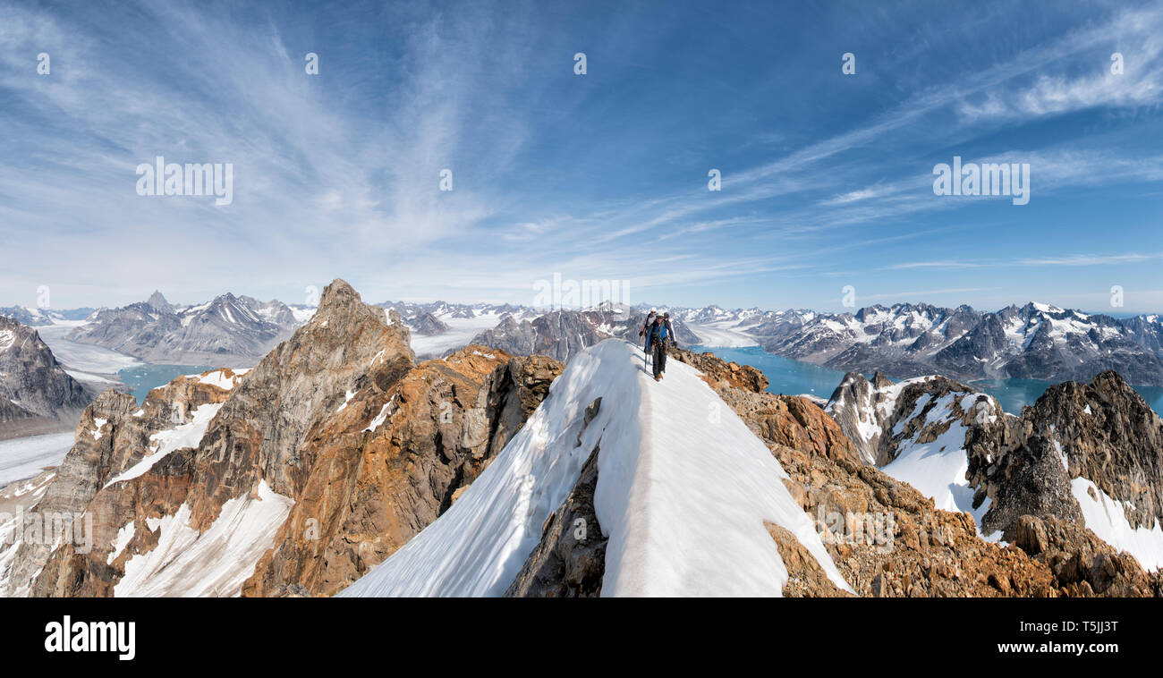 Greenland, Sermersooq, Kulusuk, Schweizerland Alps, mountaineers walking in snowy mountainscape Stock Photo