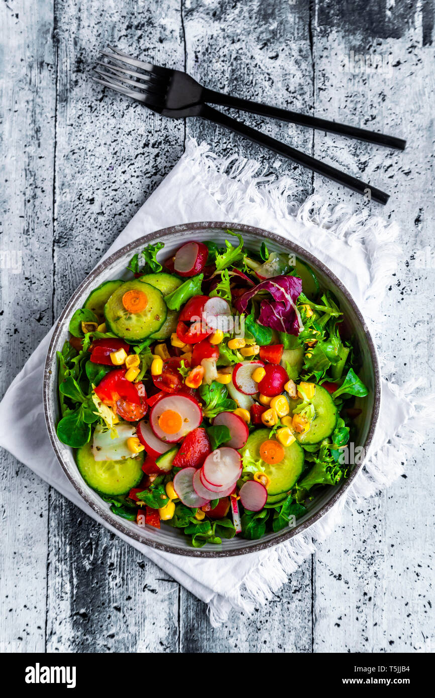 Mixed salad with red radish, cucumber, bell pepper, tomato, maize and carrot Stock Photo